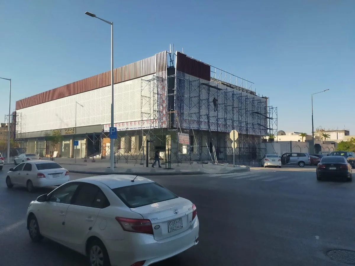 تكسية واجهة مبنى تجاري بألواح معدنية مع سقالات