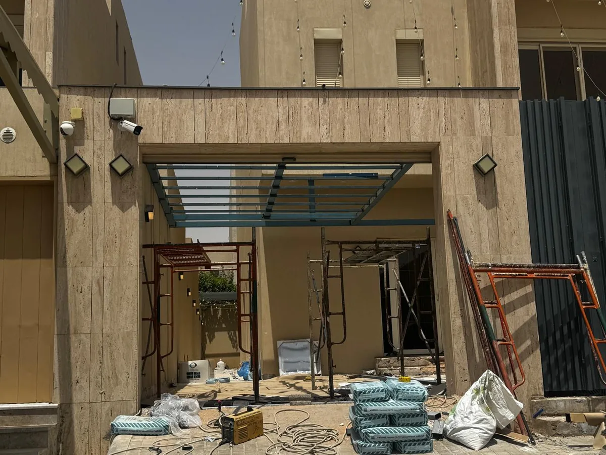 هيكل برجولة حديدية أثناء التنفيذ في فناء