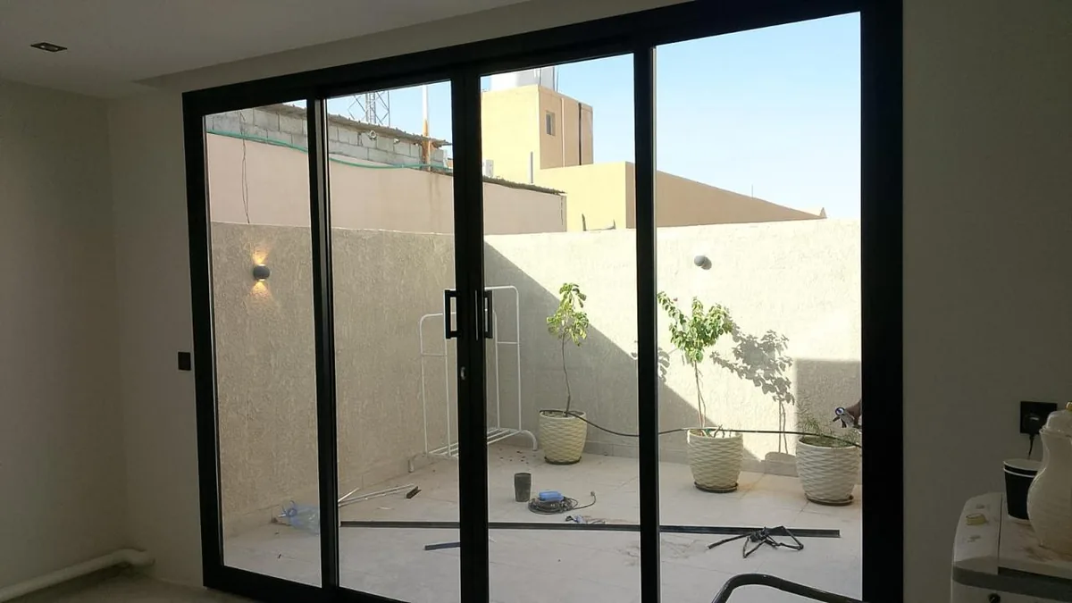 ملحق بواجهة زجاجية منزلقة يطل على فناء