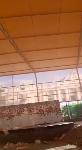 مظلة كبيرة بهيكل حديدي شبكي وغطاء قماشي فوق فناء