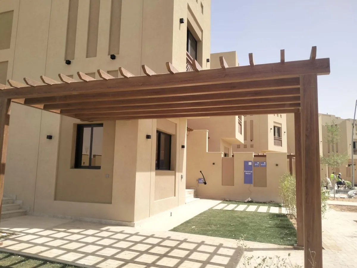 برجولة خشبية أمام مدخل وموقف سيارات فيلا